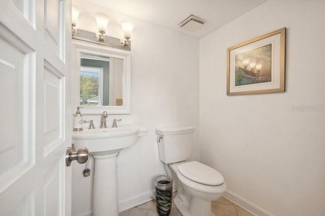 bathroom with toilet, tile patterned floors, and sink