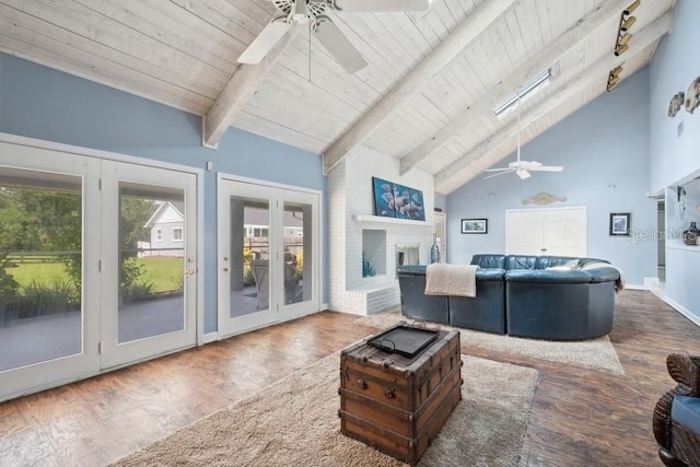 living room with a skylight, a fireplace, high vaulted ceiling, and wood-type flooring