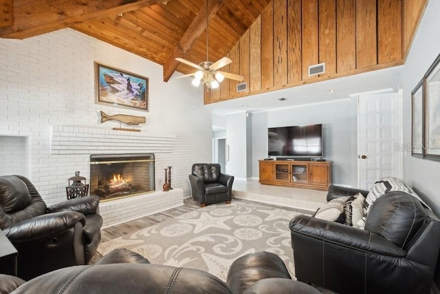 living room with beam ceiling, ceiling fan, wooden ceiling, high vaulted ceiling, and a fireplace