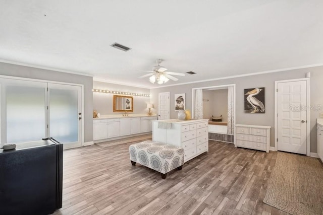 bedroom with hardwood / wood-style floors, ceiling fan, ornamental molding, and connected bathroom