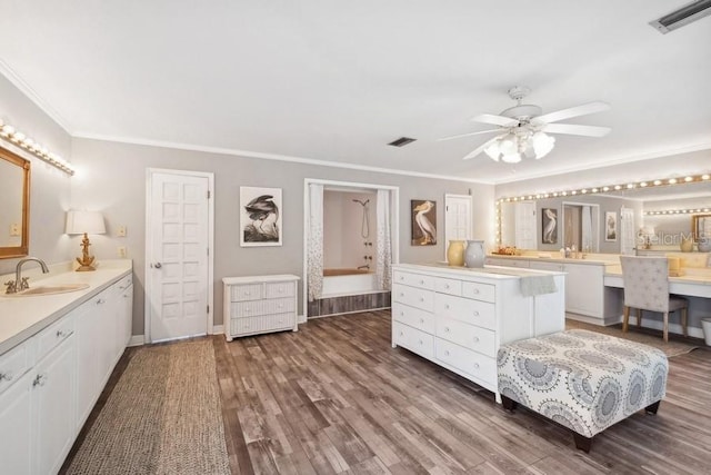 bedroom with dark hardwood / wood-style floors, ceiling fan, ornamental molding, and sink