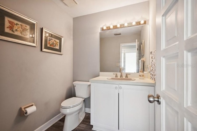 bathroom with vanity, toilet, and wood-type flooring