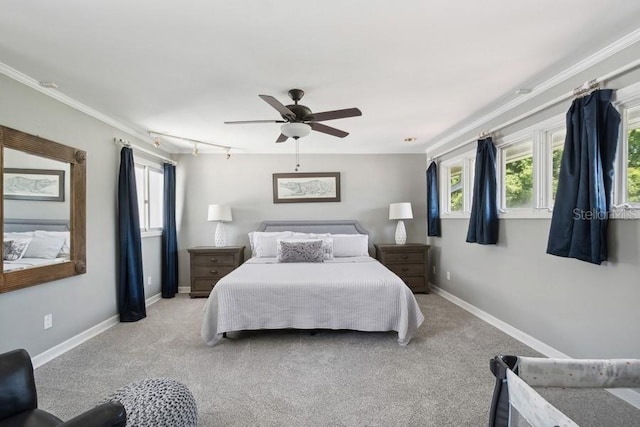 carpeted bedroom featuring track lighting, ceiling fan, and crown molding