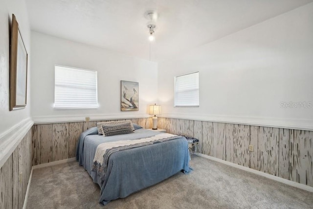 bedroom featuring carpet floors and wooden walls