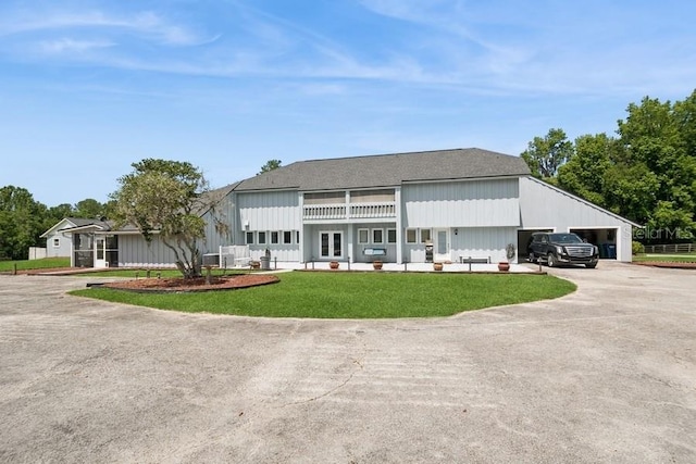 view of front of property with an outdoor living space, a garage, a balcony, and a front lawn