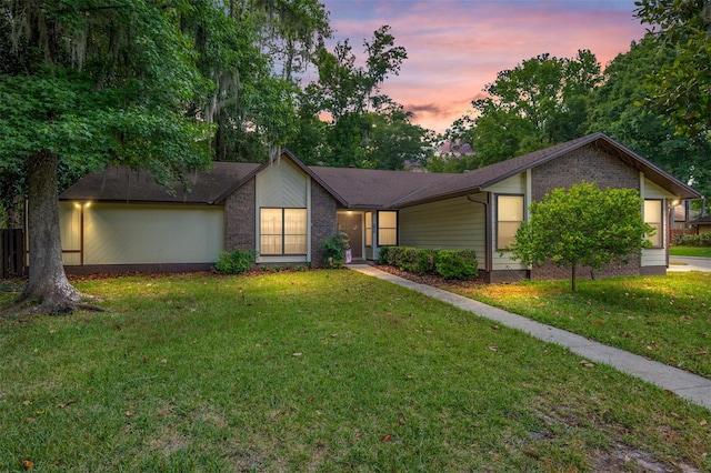 ranch-style home with a yard