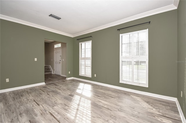 spare room with hardwood / wood-style flooring and crown molding