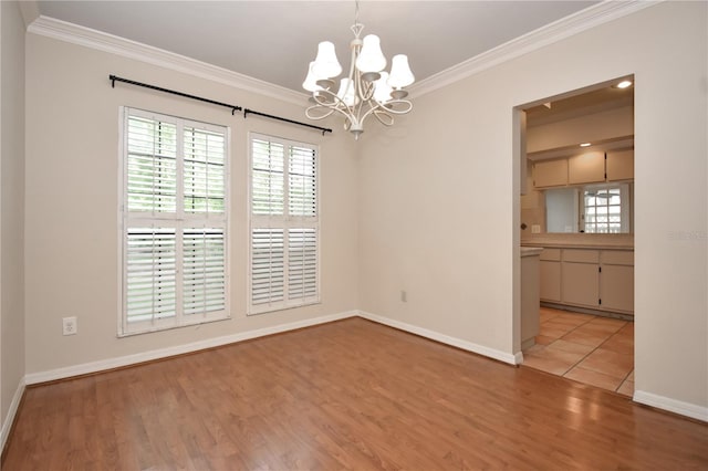 unfurnished room featuring crown molding, a chandelier, and light wood-type flooring