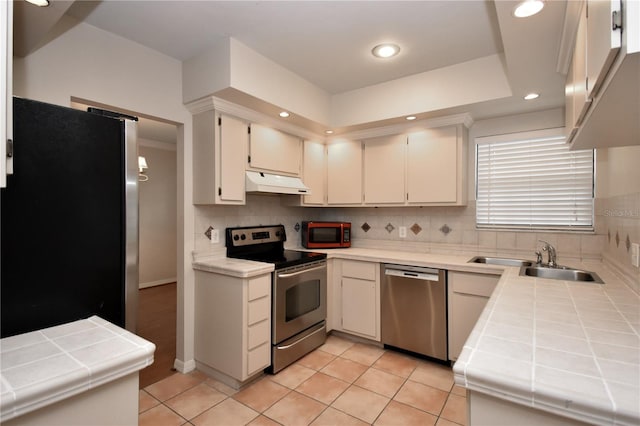 kitchen featuring tile countertops, light tile patterned floors, and stainless steel appliances