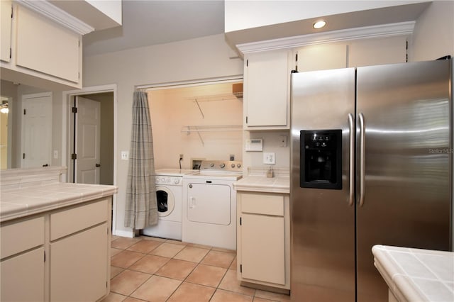 kitchen featuring tile counters, washer and dryer, stainless steel fridge with ice dispenser, and light tile patterned floors