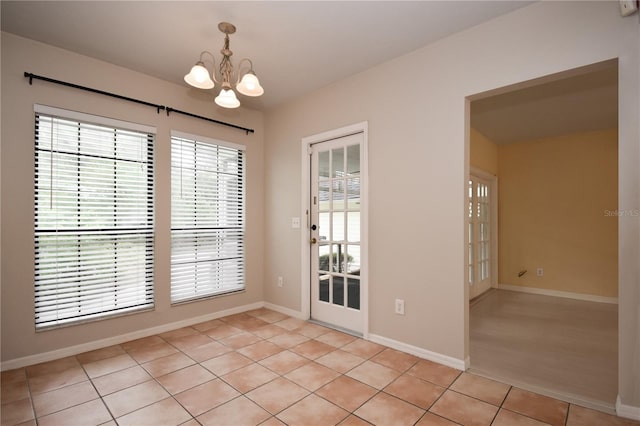 unfurnished dining area with light tile patterned floors and an inviting chandelier