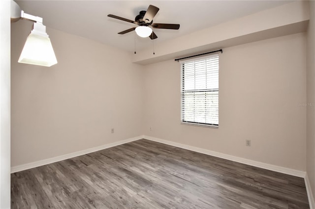 empty room with ceiling fan and dark hardwood / wood-style flooring