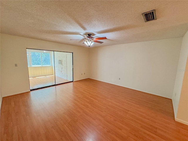 spare room featuring ceiling fan, a textured ceiling, and light wood-type flooring