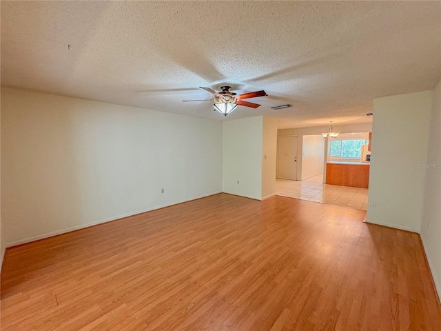 unfurnished room featuring ceiling fan, light hardwood / wood-style flooring, and a textured ceiling