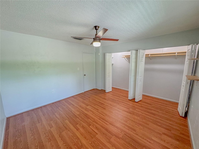 unfurnished bedroom featuring a textured ceiling, ceiling fan, and light wood-type flooring