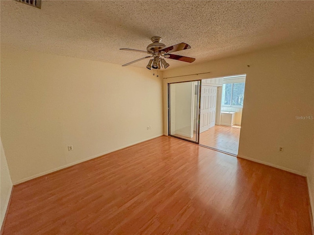 unfurnished room featuring a textured ceiling, ceiling fan, and hardwood / wood-style floors