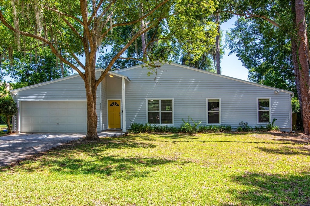 ranch-style home featuring a garage and a front yard