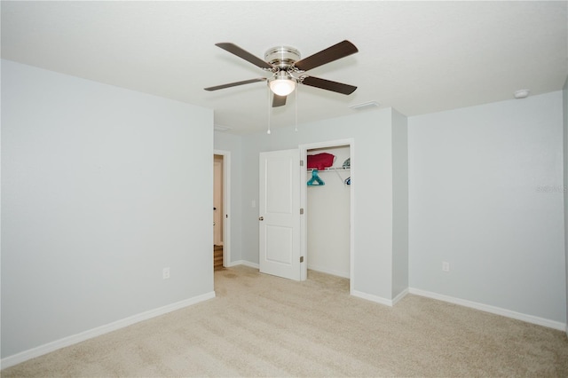 unfurnished bedroom featuring ceiling fan, a closet, and light carpet