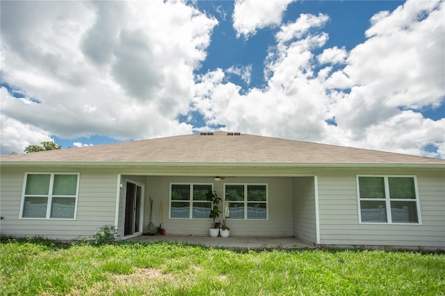 back of property with a patio and a lawn