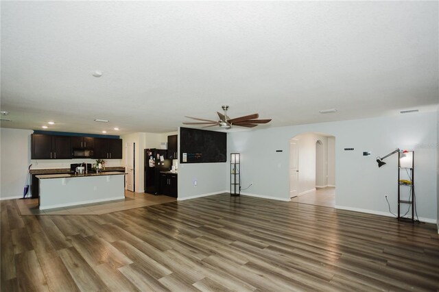 unfurnished living room with ceiling fan and wood-type flooring