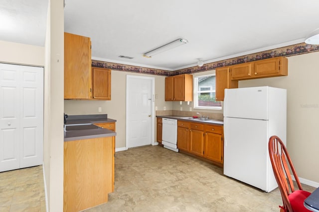 kitchen featuring sink, white appliances, and light tile floors