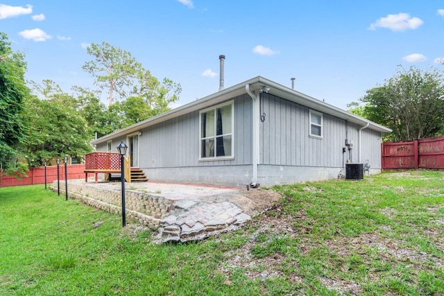 view of property exterior with a patio area, a deck, central AC, and a lawn