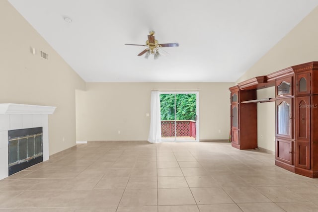 unfurnished living room featuring a tiled fireplace, light tile flooring, lofted ceiling, and ceiling fan