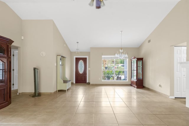 tiled foyer with a notable chandelier and high vaulted ceiling