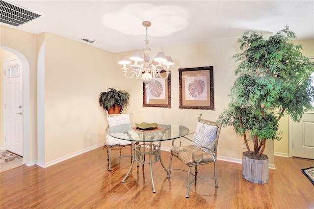 dining area with an inviting chandelier and wood-type flooring