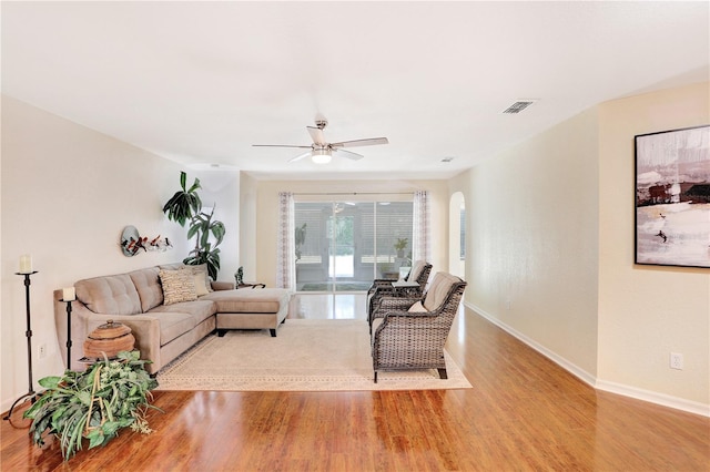 living room featuring wood-type flooring and ceiling fan