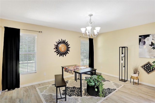 dining space with light hardwood / wood-style floors and a chandelier