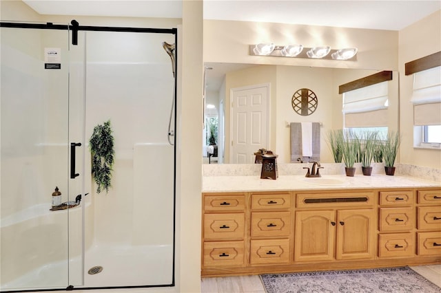 bathroom with a shower with door and vanity