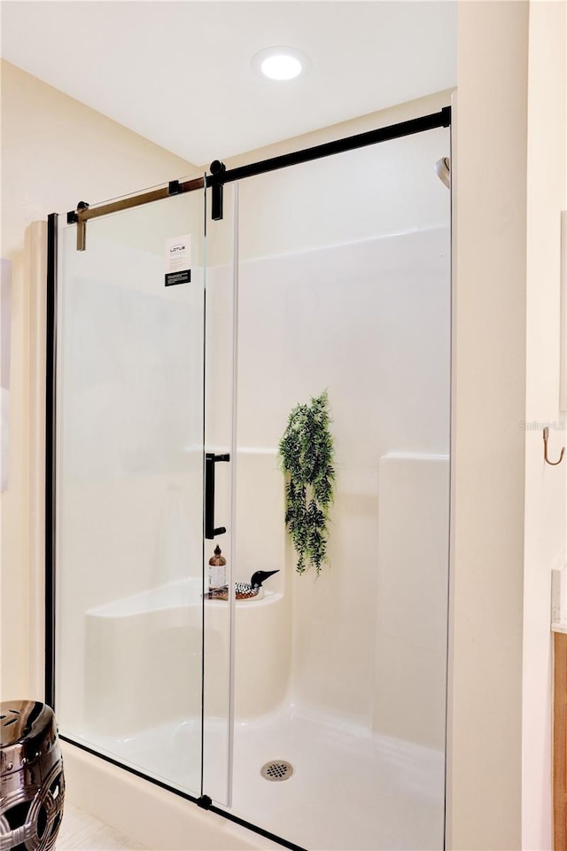 bathroom with a shower with door