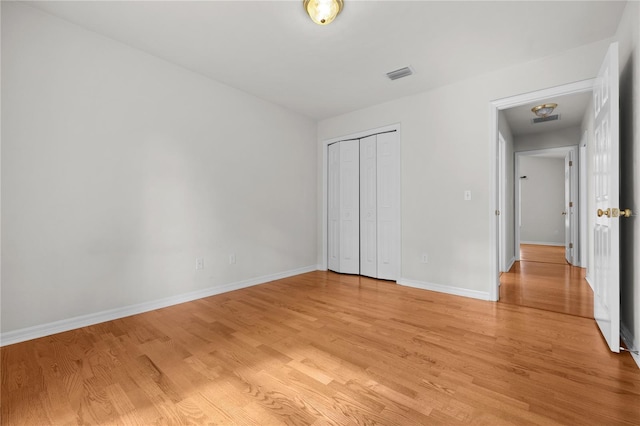 unfurnished bedroom with light hardwood / wood-style floors and a closet