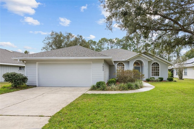 ranch-style home featuring a garage and a front lawn