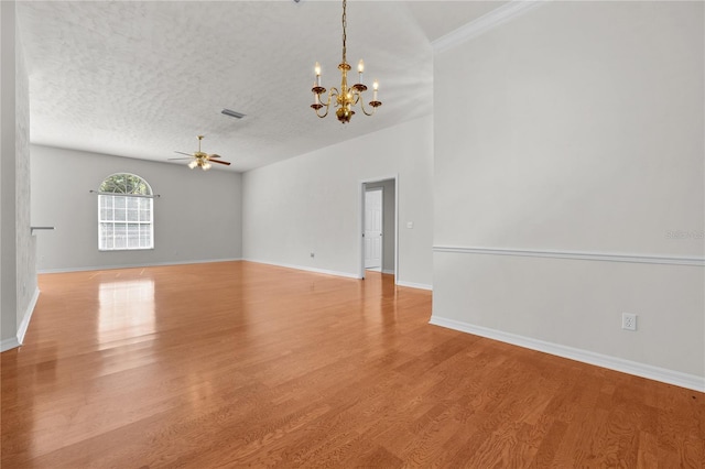 empty room with ceiling fan with notable chandelier, a textured ceiling, and light hardwood / wood-style flooring