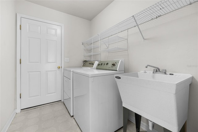 clothes washing area featuring sink and washer and dryer