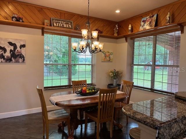 dining room with a wealth of natural light, wooden walls, and an inviting chandelier