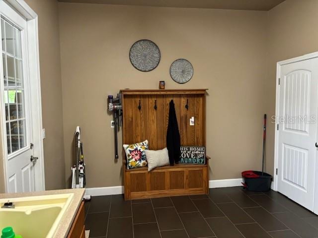 mudroom with sink and dark tile flooring