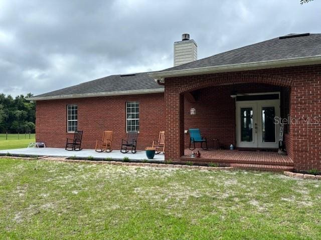 rear view of house featuring a patio area, french doors, and a yard