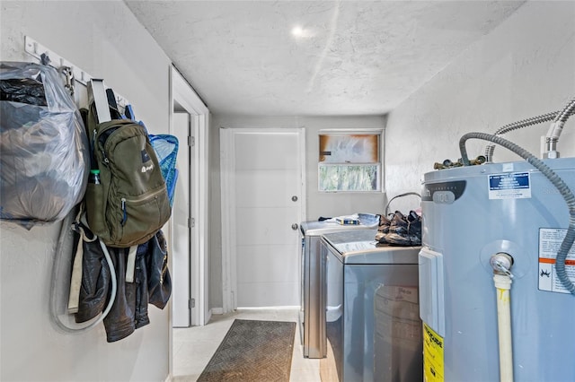 washroom with washer and clothes dryer, a textured ceiling, and water heater