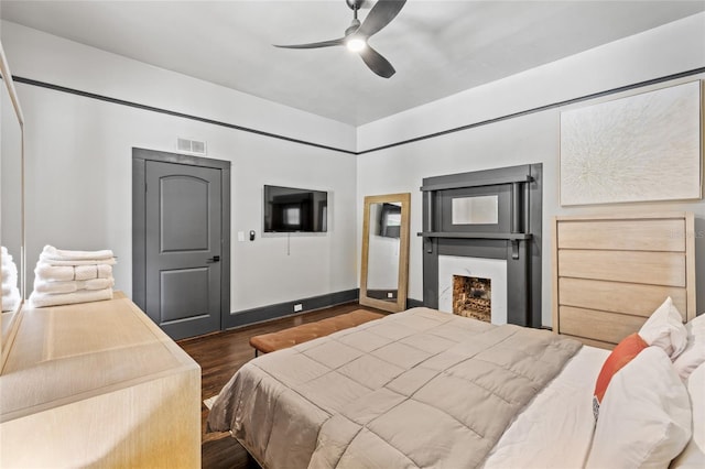 bedroom with dark hardwood / wood-style flooring and ceiling fan