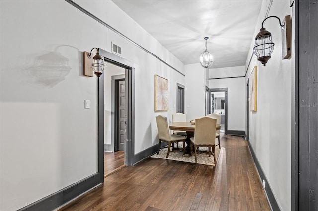 dining area featuring a notable chandelier and dark hardwood / wood-style floors