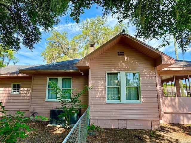 view of property exterior featuring cooling unit and a sunroom