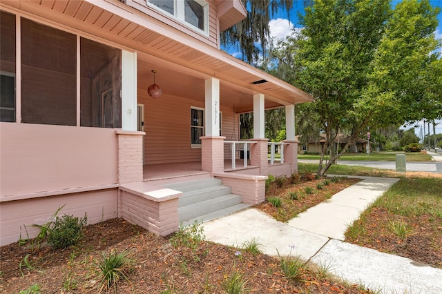 view of exterior entry with covered porch