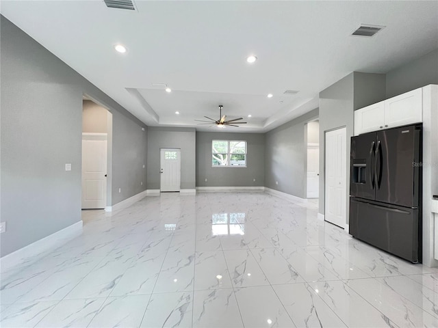 interior space with ceiling fan and a tray ceiling