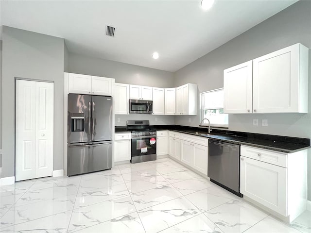 kitchen with sink, white cabinets, light tile floors, and appliances with stainless steel finishes