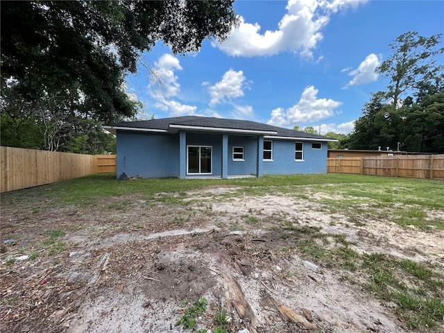 back of house with a lawn