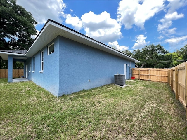 view of home's exterior with central AC and a yard