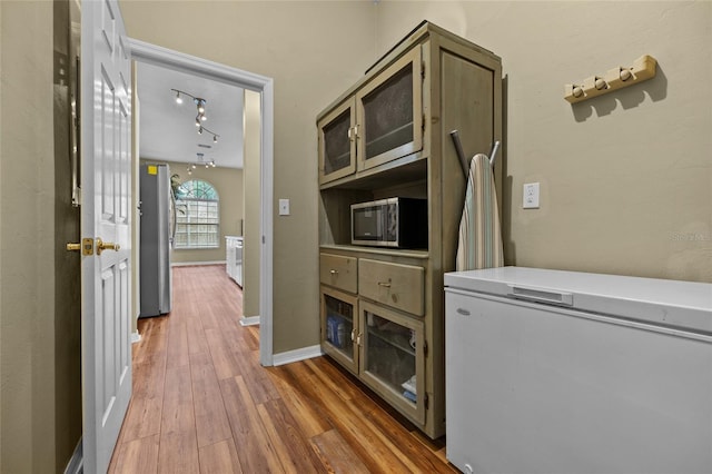 interior space featuring rail lighting and dark hardwood / wood-style flooring